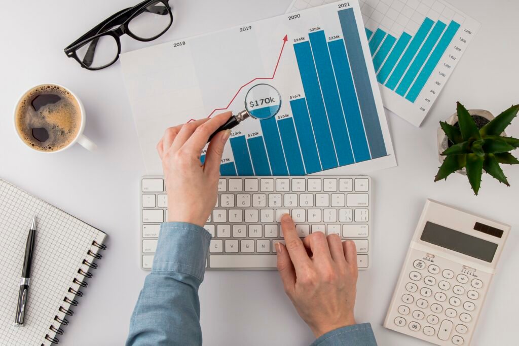 top view office desk with growth chart analyzed with magnifying glass 1024x683 1